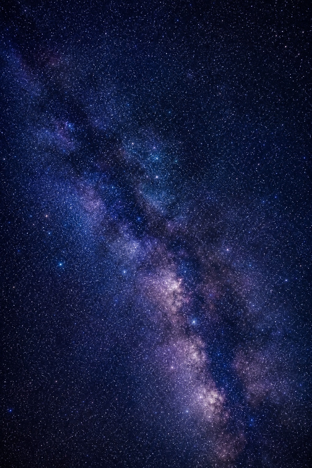 A deep blue star field with a glowing band of stars across the center.