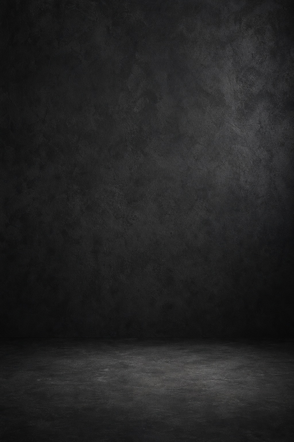 Dark vertical charcoal studio backdrop with a soft textured floor surface and subtle shadow
