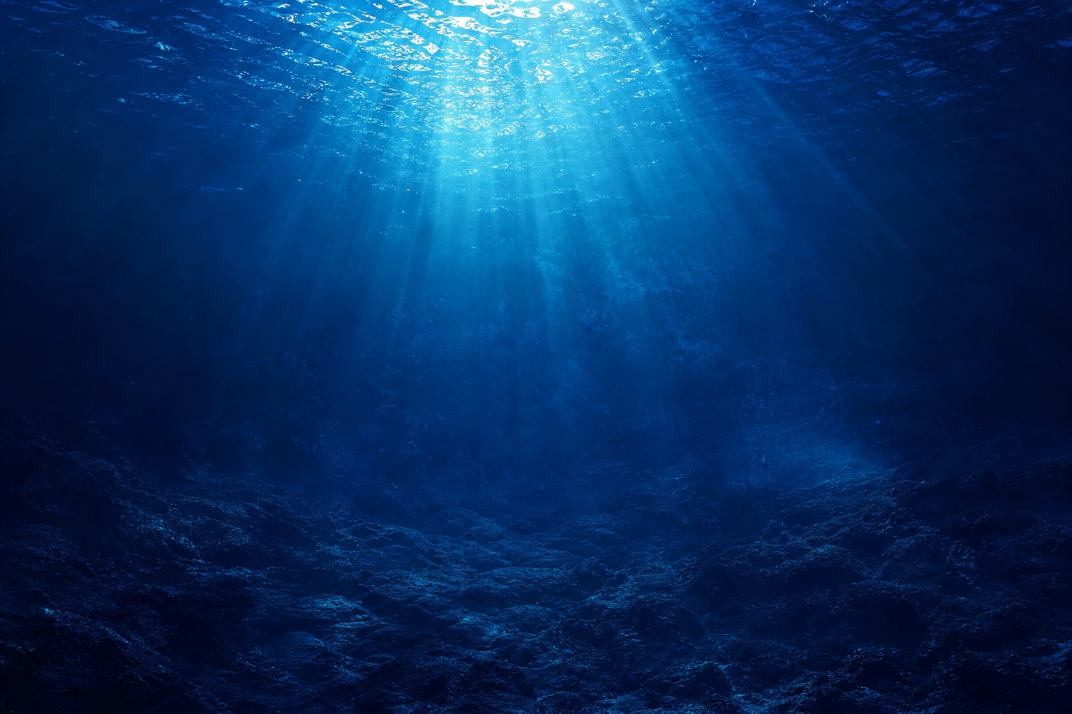 Blue underwater scene with light rays streaming down through ocean water