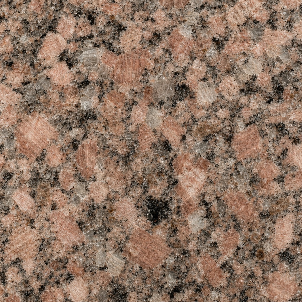 Polished rose granite surface with mixed crystalline speckled texture and stone pattern