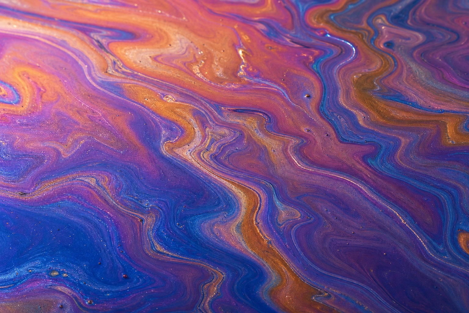 Abstract violet, copper, blue, and orange marbled film texture with swirling fluid patterns.