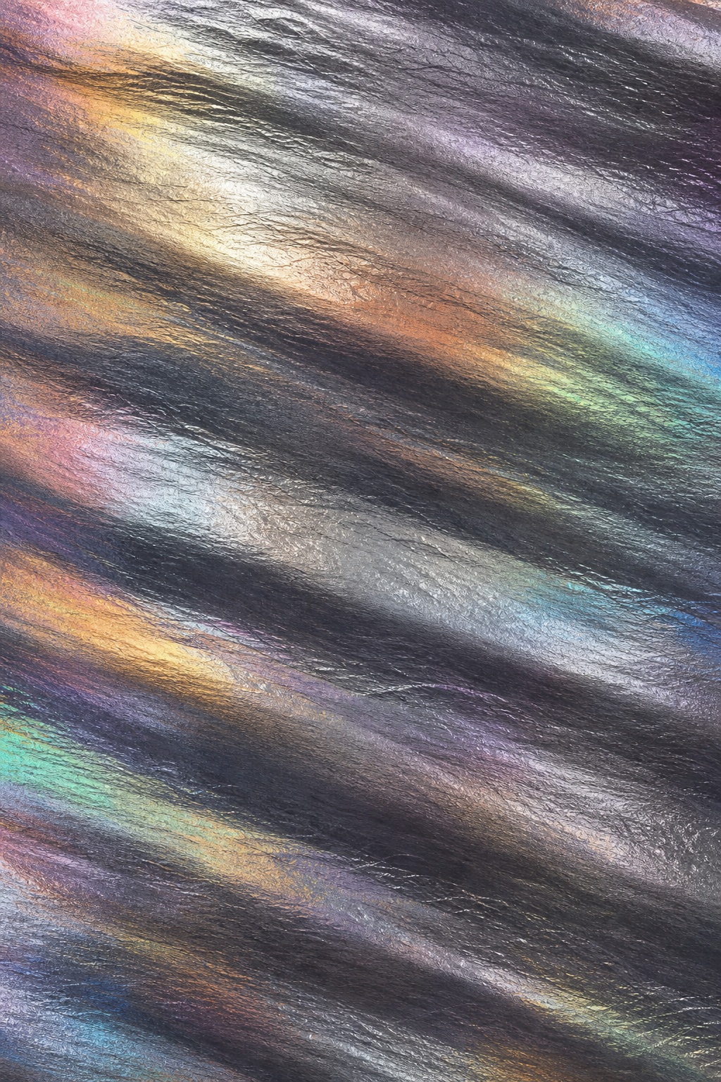 Diagonal graphite foil ridges with rainbow shimmer and metallic reflections