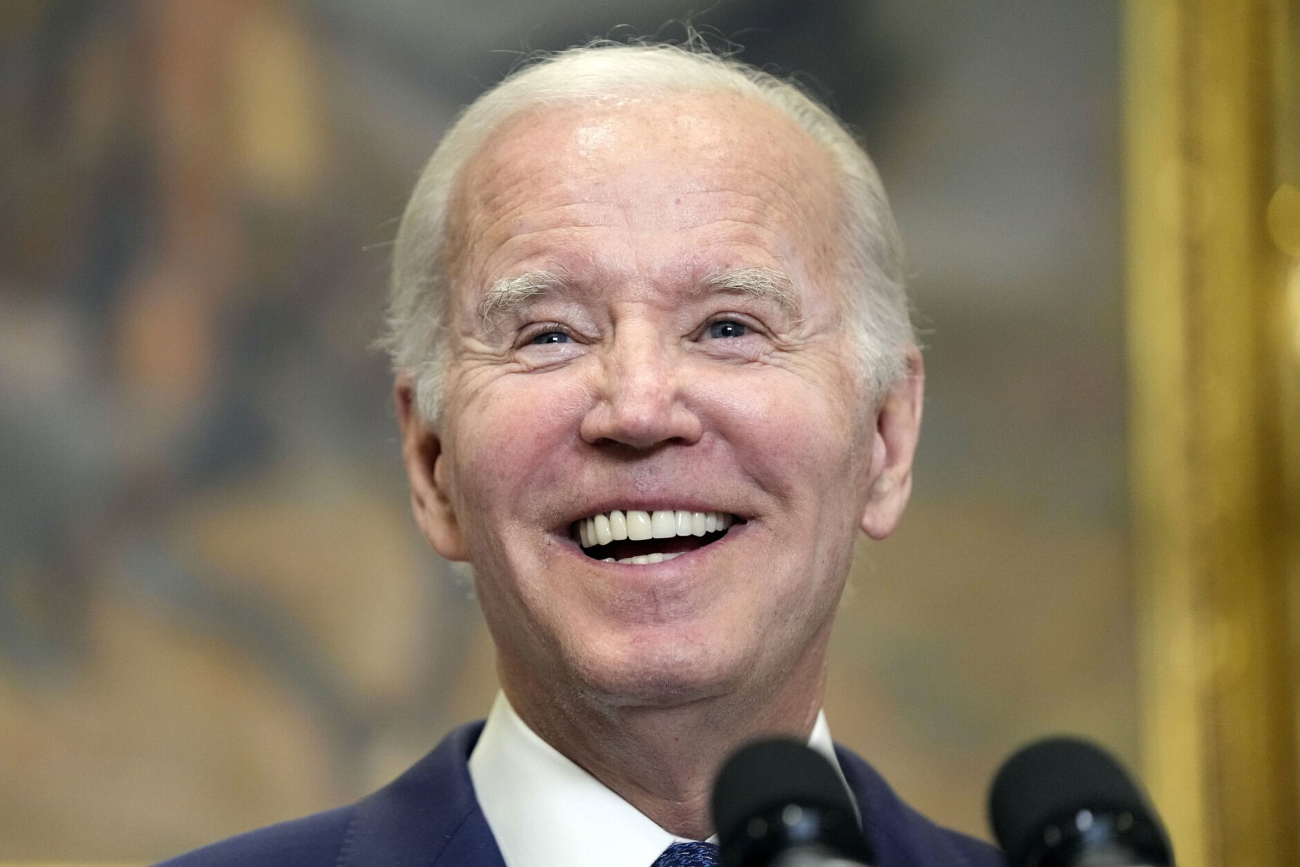 Smiling man speaking at a podium during an event