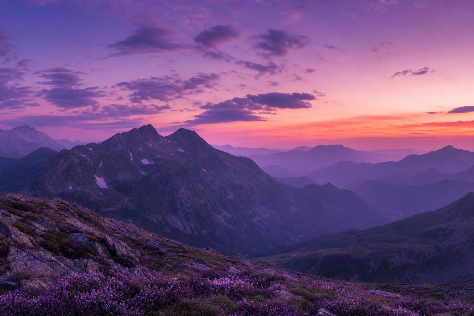 Misty mountains under a lavender dusk sky with layered silhouettes and fog