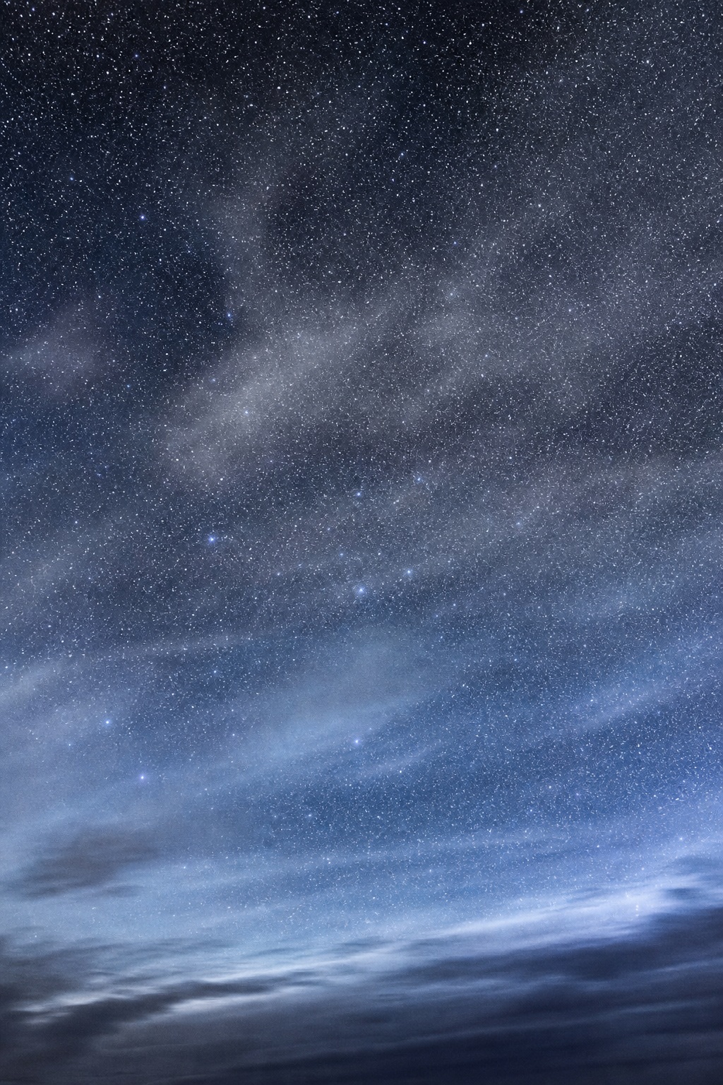 Silver blue night sky with stars and soft hazy clouds