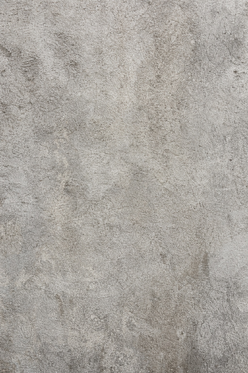 Vertical gray rough concrete surface with subtle mottled texture