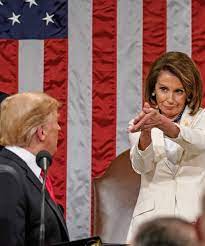 Nancy Pelosi clapping while Donald Trump looks on at a political event