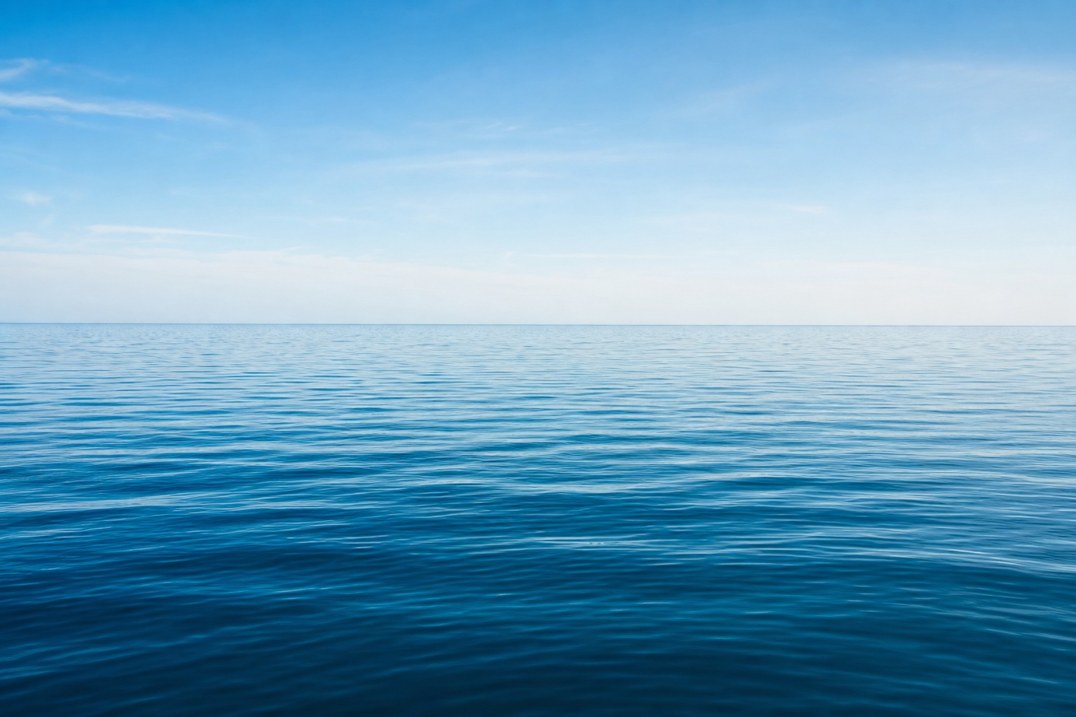 Calm blue ocean with a distant horizon under a clear sky