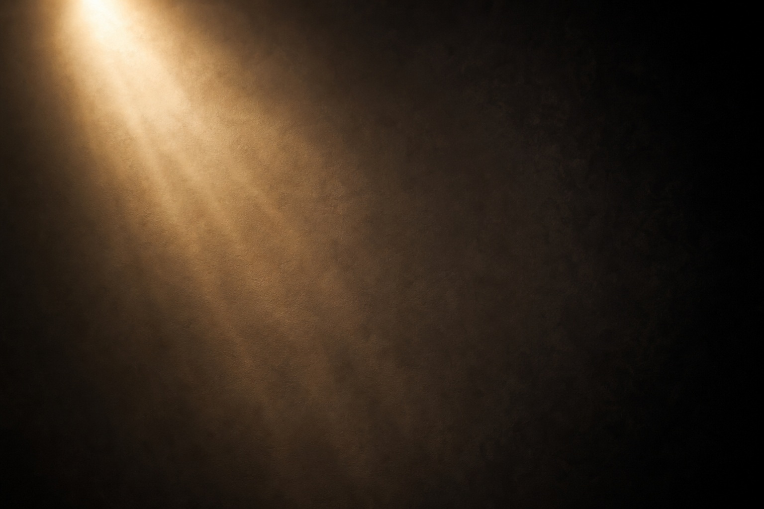 Warm light rays fading into a dark studio background
