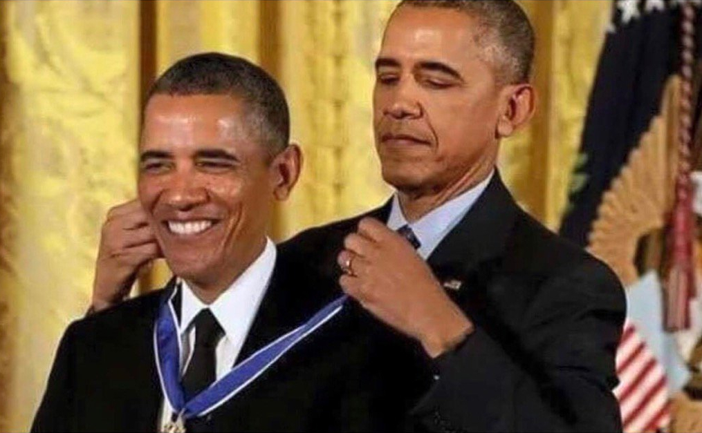 Barack Obama places a medal around another man's neck during a ceremony.