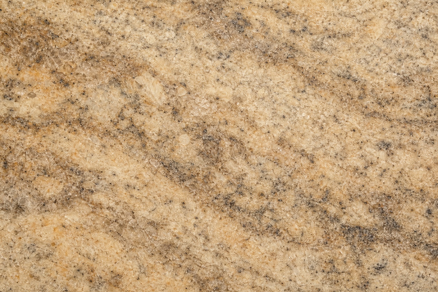 Warm beige clouded granite surface with fine mineral grain and soft cloudy streaks