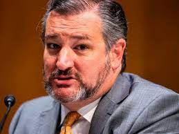 Man in a suit speaking at a microphone on a warm brown background