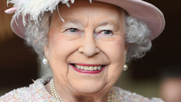 Queen Elizabeth II smiling in a floral dress and hat