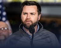 Man with beard speaking into a microphone