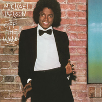 Michael Jackson in a black tuxedo standing against a brick wall with Off the Wall written on it