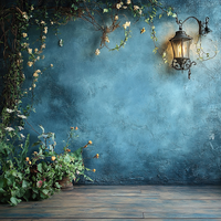 Vintage lantern hanging on a blue textured wall with floral arrangement