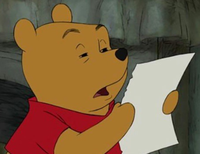 Winnie the Pooh in a red shirt holding a white paper