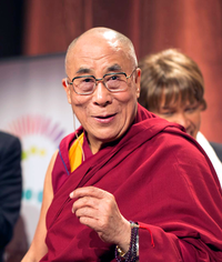 The Dalai Lama smiling and wearing red robes