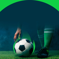 A soccer player's leg and a soccer ball on a green field