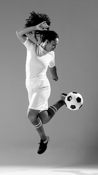 Woman kicking soccer ball