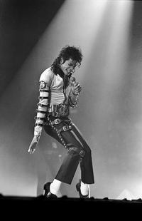Michael Jackson performing live on stage in a spotlight