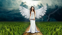Angel in white dress with wings standing on a path in a stormy landscape