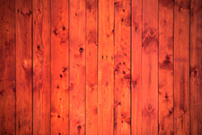 Red wooden plank texture with visible knots and grain