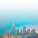 Blurry city skyline with tall buildings and a bridge at dusk.