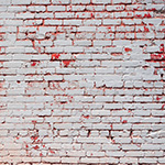 Distressed white brick wall with red undertones