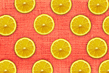 Pattern of orange slices on a red textured background