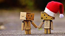 Two Danbo cardboard box figures holding hands, one wearing a Santa hat