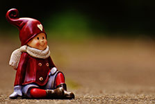 Small Christmas elf figurine sitting on the ground