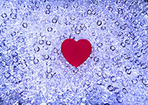 Red heart on a blue background with water droplets