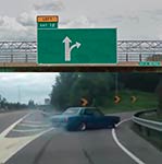 Car merging onto highway with green directional sign