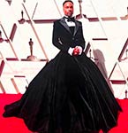 Billy Porter wearing a black tuxedo gown on the Oscars red carpet