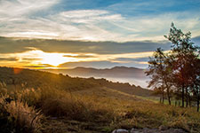 A serene landscape with rolling hills and mountains at sunrise