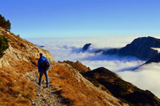 Hiker on a mountain ridge above clouds