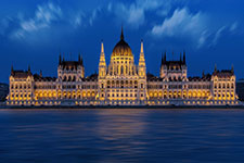 Hungarian Parliament Building lit up at night with reflection on the Danube River