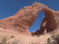 A large natural rock arch in a desert landscape