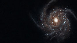 Image of a spiral galaxy with a bright center and numerous stars