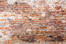 Distressed brick wall with peeling white paint