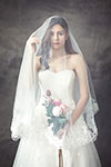 Bride in a white strapless wedding dress with a veil and bouquet