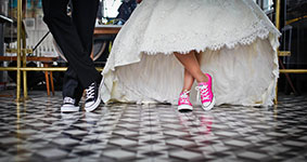 Bride wearing pink sneakers under white wedding dress