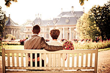 Couple embracing on a bench in a garden