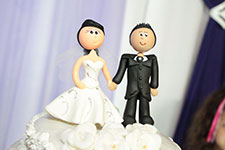 Bride and groom cake toppers on a wedding cake